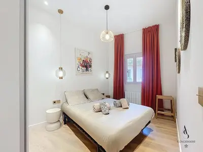 a bedroom with a bed and a red curtain at Le Forville - 2 chambres - 5 min Palais - Suquet in Cannes