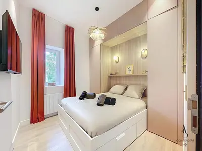 a bedroom with a white bed and red curtains at Le Forville - 2 chambres - 5 min Palais - Suquet in Cannes
