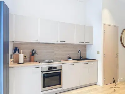 a kitchen with white cabinets and a sink at Le Forville - 2 chambres - 5 min Palais - Suquet in Cannes