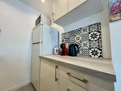a kitchen with a refrigerator and a counter at Le Versailles By SCLS Locations in Cannes