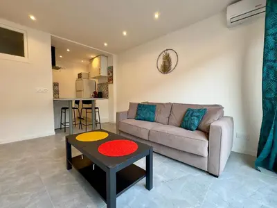 a living room with a couch and a table at Le Versailles By SCLS Locations in Cannes