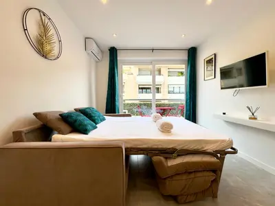 a living room with a bed and a couch at Le Versailles By SCLS Locations in Cannes