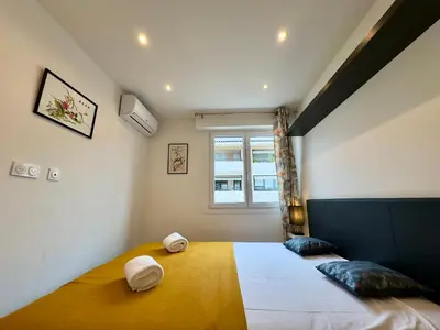 a bedroom with a bed with two pillows and a window at Le Versailles By SCLS Locations in Cannes