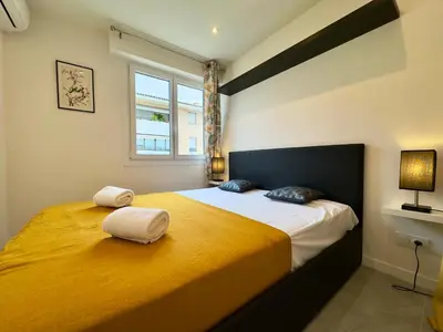 a bedroom with a large bed with two towels on it at Le Versailles By SCLS Locations in Cannes