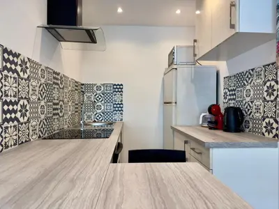 a kitchen with a counter top and a refrigerator at Le Versailles By SCLS Locations in Cannes