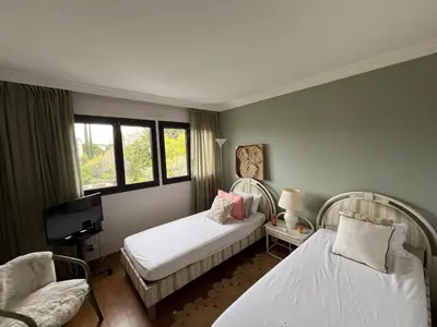 a bedroom with two beds and a chair and window at Appt 2ch 90m2 avec terrasse 40m2, piscine et tennis in Cannes