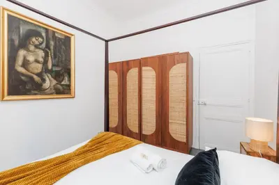 a bedroom with a bed with a painting on the wall at Immogroom - Renovated & Cozy One-Bedroom Flat in Cannes