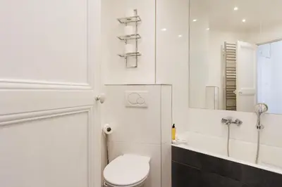 a white bathroom with a toilet and a sink at Immogroom - Renovated & Cozy One-Bedroom Flat in Cannes
