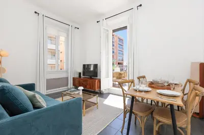 a living room with a blue couch and a table at Immogroom - Renovated & Cozy One-Bedroom Flat in Cannes
