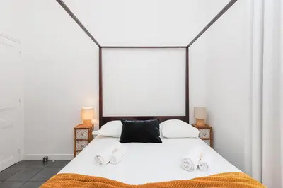 a bedroom with a white bed with a black pillow at Immogroom - Renovated & Cozy One-Bedroom Flat in Cannes