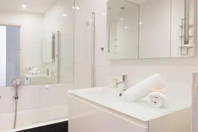 a white bathroom with a sink and a shower at Immogroom - Renovated & Cozy One-Bedroom Flat in Cannes
