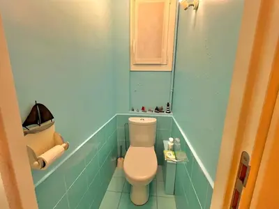 a small bathroom with a toilet and blue tiles at Two rooms near Martinez in Cannes