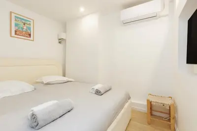 a bedroom with a white bed with towels on it at El Sole - Plage - Wifi - Croisette in Cannes