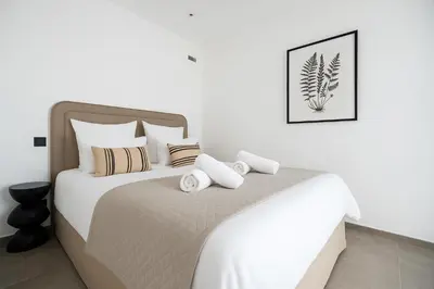 a bedroom with a large white bed with pillows at Mediterranean Cosy Studio in Cannes