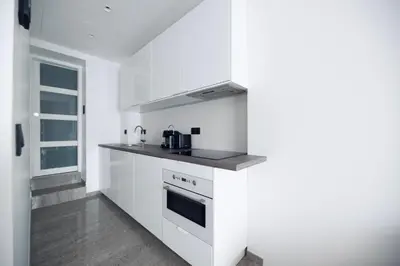a white kitchen with a stove and a sink at Mediterranean Cosy Studio in Cannes