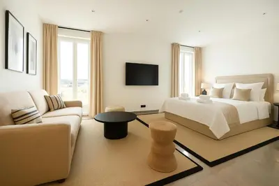 a white bedroom with a bed and a couch at French Dolce Vita near Croisette in Cannes