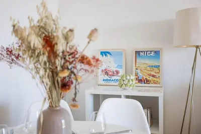a table with two chairs and a vase with flowers at Perchoir - Balcon, vue sur la ville, Palais&Plages in Cannes