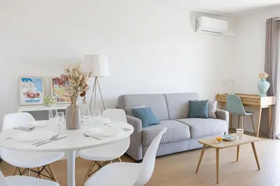 a living room with a couch and a table and chairs at Perchoir - Balcon, vue sur la ville, Palais&Plages in Cannes