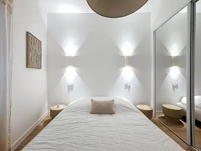 a bedroom with a bed with lights on the wall at Effet Mer - neuf, central, Port, Plage&Palais, clim in Cannes