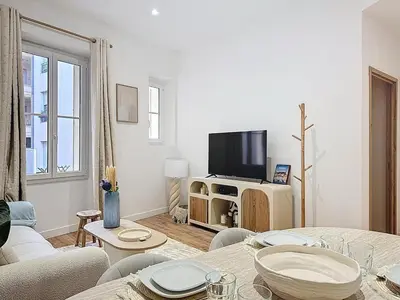 a living room with a couch and a tv at Effet Mer - neuf, central, Port, Plage&Palais, clim in Cannes