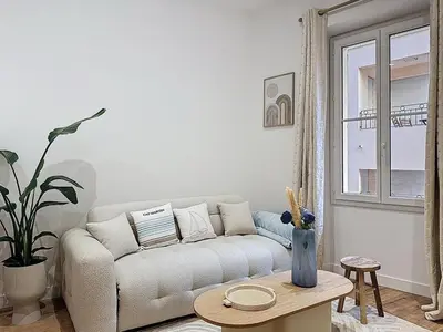 a living room with a couch and a table at Effet Mer - neuf, central, Port, Plage&Palais, clim in Cannes