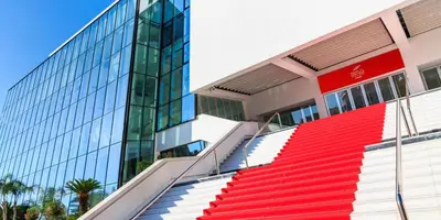 a building with red and white stairs next to a glass building at Seaview Studio, Palais des Festivals in Cannes