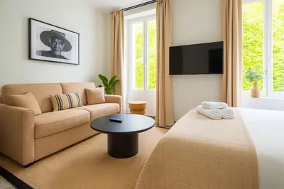 a bedroom with a bed and a couch and a table at Croisette Palais des Festivals Studio in Cannes