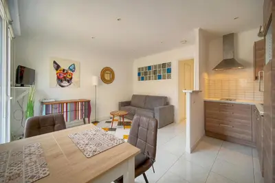 a kitchen and living room with a table and a couch at Studio lumineux avec balcon A0B207 in Cannes
