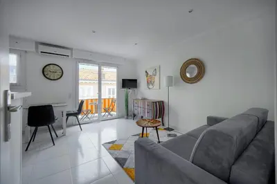 a living room with a couch and a table at Studio lumineux avec balcon A0B207 in Cannes