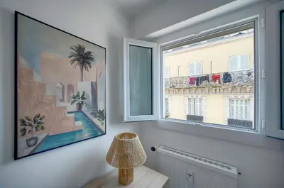 a room with a window and a picture of a building at Studio lumineux avec balcon A0B207 in Cannes