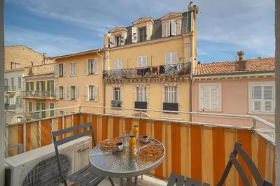 a balcony with a table and chairs and a building at Studio lumineux avec balcon A0B207 in Cannes