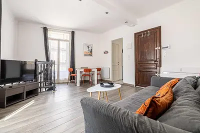 a living room with a couch and a flat screen tv at LA MAISON DU SUQUET duplex avec terrasse en plein centre in Cannes