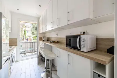 a kitchen with white cabinets and a microwave oven at LA MAISON DU SUQUET duplex avec terrasse en plein centre in Cannes