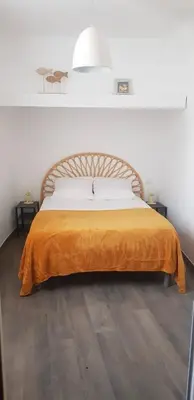a bedroom with a bed with an orange blanket at LA MAISON DU SUQUET duplex avec terrasse en plein centre in Cannes