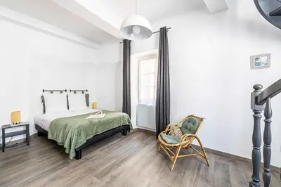 a bedroom with a bed and a chair at LA MAISON DU SUQUET duplex avec terrasse en plein centre in Cannes