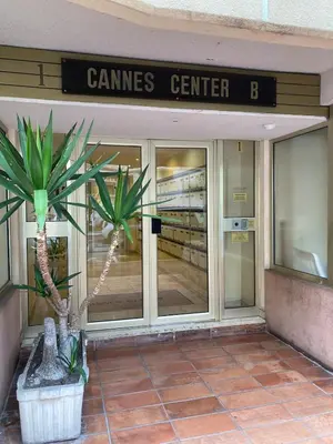 a store front with two palm trees in front of it at Pause Riviera avec terrasse, à 300 mètres de la mer in Cannes