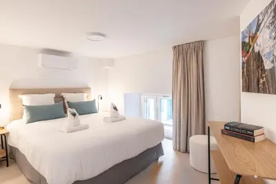 a bedroom with a large white bed and a desk at Cosy T2 in Cannes in Cannes