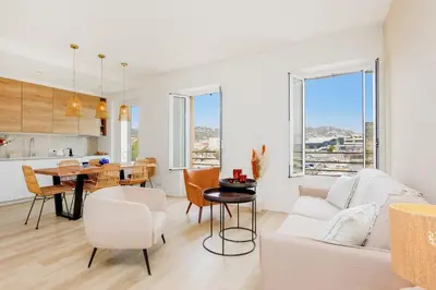a living room with a couch and a table at Modern 2 Bedroom Overlooking Cannes Old Port in Cannes