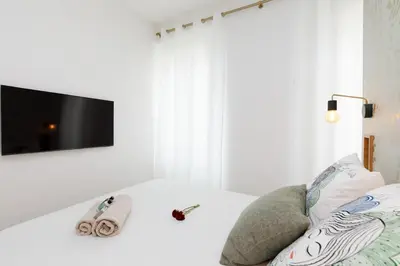 a white room with a tv on a white wall at Modern 2 Bedroom Overlooking Cannes Old Port in Cannes