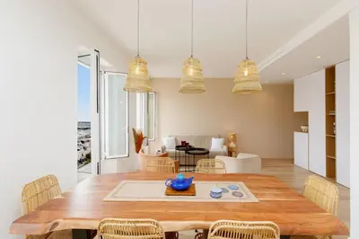 a kitchen and dining room with a wooden table and chairs at Modern 2 Bedroom Overlooking Cannes Old Port in Cannes