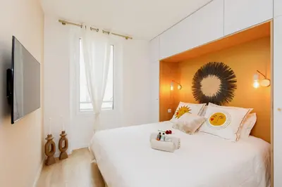 a bedroom with a large white bed with a window at Modern 2 Bedroom Overlooking Cannes Old Port in Cannes