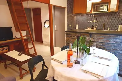 a table with a white table cloth and a bottle of wine at Logement très confortable et bien situé à Cannes in Cannes