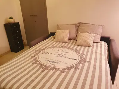 a bed with a blanket with a sign on it at Logement très confortable et bien situé à Cannes in Cannes