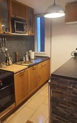 a kitchen with wooden cabinets and a microwave at Logement très confortable et bien situé à Cannes in Cannes