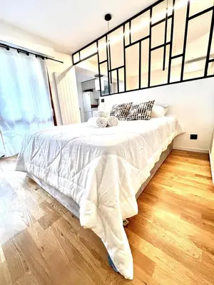 a bedroom with a large bed with white sheets at Studio La Baronne in Cannes