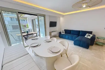 a living room with a table and a blue couch at Wide and sunny 3 BR 2 Baths heart of Cannes gorgeous terrace city ctr in Cannes