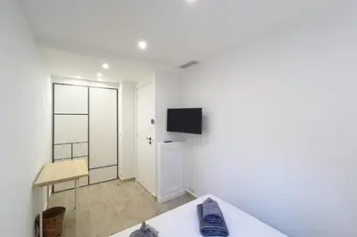 a white room with a table and a tv on the wall at Wide and sunny 3 BR 2 Baths heart of Cannes gorgeous terrace city ctr in Cannes