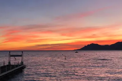a sunset over a body of water with a pier at Wide and sunny 3 BR 2 Baths heart of Cannes gorgeous terrace city ctr in Cannes