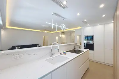 a white kitchen with a sink and a counter at Wide and sunny 3 BR 2 Baths heart of Cannes gorgeous terrace city ctr in Cannes
