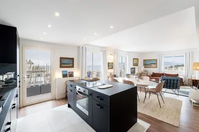 a kitchen and living room with a view of a living room at Geoffrey By Terrys Homes in Cannes